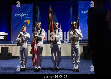 NATIONAL HARBOUR, MD. (4. August 2021) die Zeremonialgarde der Naval Capital Region pariert die Farben während der Ausstellung Sea-Air-Space 2021. Die Sea-Air-Space Exposition ist eine jährliche Veranstaltung, bei der wichtige militärische Entscheidungsträger, der US-Verteidigungsstützpunkt und private US-Unternehmen zu einer innovativen und lehrreichen maritimen Veranstaltung zusammenkommen. Stockfoto