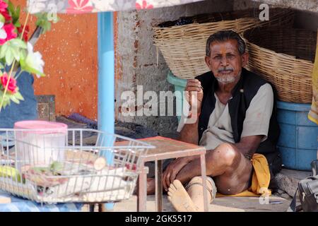 Orchha, Madhya Pradesh, Indien - 2019. März: Ein indischer männlicher Straßenhändler, der allein im Leerlauf in seinem Straßenrand-Stall sitzt. Stockfoto