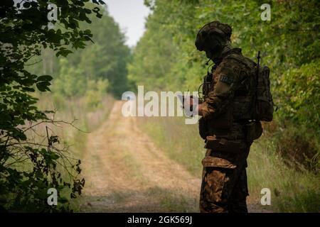 Ein lettischer Joint Terminal Attack Controller untersucht eine Karte während einer Übung im Carmeuse Lime and Stone Quarry, Rogers City, Michigan, 4. August 2021, Als Teil von Northern Strike. Northern Strike ist eine gemeinsame, mehrkomponentige, multinationale Übung, die darauf ausgerichtet ist, Bereitschaft zu schaffen und die Interoperabilität mit Koalitionstruppen zu verbessern, um zu kämpfen und zu gewinnen. Der Northern Strike, die größte und längste Übung der Michigan National Guard, die die Bereitschaft der gemeinsamen Reserveeinheit bestätigen soll, findet vom 31. Juli 2021 bis zum 14. August 2021 im National All-Domain Warfighting Center statt. Der NADWC überspannt Michi Stockfoto