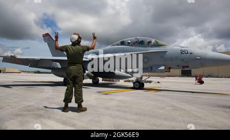 U.S. Marine Corps Lance CPL. Justin Delrio, ein Mechaniker für stationäre Flugzeuge, links, meldet Maj. Nils Alpers, F/A-18 Hornet Pilot, oben rechts, und Capt. Conner Allender, F/A-18 Hornet Waffensystemoffizier mit Marine Fighter Attack Squadron (VMFA) 232 auf der Andersen Air Force Base, Guam, während Pacific Iron 2021, 4. August 2021. Pacific Iron 2021 konzentriert sich auf den Einsatz, den Betrieb und die Unterstützung von Kräften aus kleineren, verstreuten Stützpunkten in der Region Indo-Pazifik. Stockfoto