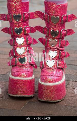 Modische rosa Platformstiefel mit zahlreichen Liebe Herz Schnallen von einem Teenager / Teenager in der Straße / Straße Mode getragen. (127) Stockfoto