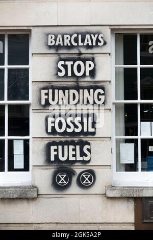 Graffiti, darunter das Logo der Extinction Rebellion, das auf einer Wand der Barclays Bank geschrieben wurde und gegen die Verwendung fossiler Brennstoffe protestiert, verursachen die globale Erwärmung und den Klimawandel. Lewes in East Sussex, Großbritannien. (127) Stockfoto