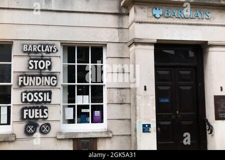 Graffiti, darunter das Logo der Extinction Rebellion, das auf einer Wand der Barclays Bank geschrieben wurde und gegen die Verwendung fossiler Brennstoffe protestiert, verursachen die globale Erwärmung und den Klimawandel. Lewes in East Sussex, Großbritannien. (127) Stockfoto