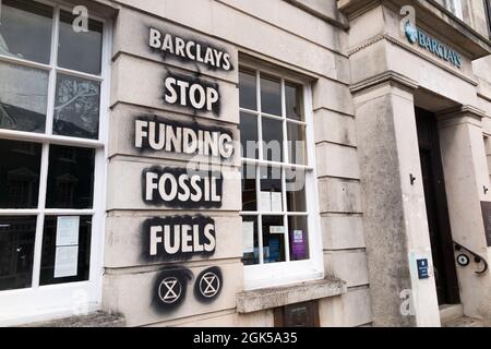 Graffiti, darunter das Logo der Extinction Rebellion, das auf einer Wand der Barclays Bank geschrieben wurde und gegen die Verwendung fossiler Brennstoffe protestiert, verursachen die globale Erwärmung und den Klimawandel. Lewes in East Sussex, Großbritannien. (127) Stockfoto