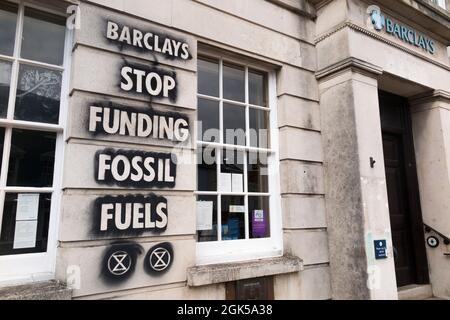 Graffiti, darunter das Logo der Extinction Rebellion, das auf einer Wand der Barclays Bank geschrieben wurde und gegen die Verwendung fossiler Brennstoffe protestiert, verursachen die globale Erwärmung und den Klimawandel. Lewes in East Sussex, Großbritannien. (127) Stockfoto