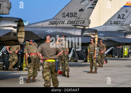 Mehrere Flieger mit der Flugzeugwartung des 114. Kampfflügels bereiten sich auf den Start eines F-16 Fighting Falcon während einer Übung zur Alarmbereitschaft auf dem Joe Foss Field, S. D., 5. August 2021 vor. Die Bereitschaftsübung wurde entwickelt, um die Fähigkeit des 114. Kampfflügels zu testen, kurzfristig auf Bedrohungen in der Nähe des Joe Foss Feldes zu reagieren. Stockfoto