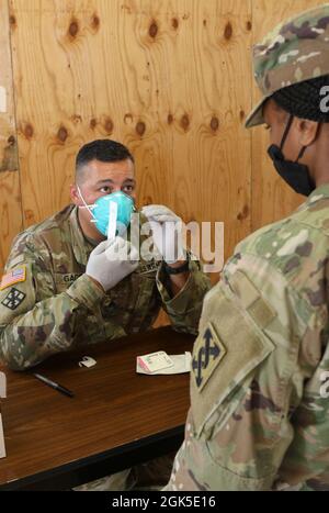 US Army Sgt. Franklin Gago, 7202. Medizinische Unterstützungseinheit, weist einen Soldaten der 642. Regionalen Unterstützungsgruppe an, einen COVID-Test bei der Kampfunterstützungsübung in Fort McCoy, Wis., 6. August 2021 selbst durchzuführen. Medizinische Soldaten haben Soldaten, die an der Veranstaltung teilnahmen, auf COVID untersucht, um die Ausbreitung des Virus zu verhindern und die Truppen gesund zu halten. Die 7202 Medical Support Unit hat ihren Sitz in Shoreham, NY, während die 642. Regional Support Group von Decatur, Georgia, stammt Stockfoto