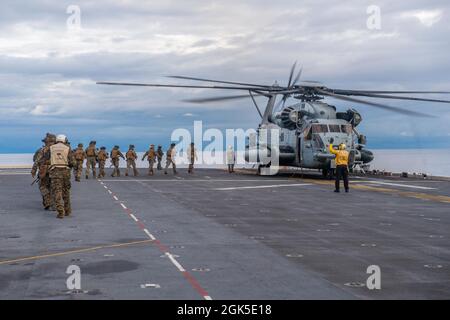 PAZIFIK (Aug 6, 2021) Seeleute und Marineinfanteristen, die dem vorwärts eingesetzten amphibischen Sturmschiff USS America (LHA 6) und der 31. Marine Expeditionary Unit (MEU) zugewiesen wurden, besteigen einen CH-53E Super Hengst-Hubschrauber vom 31. MEU für eine schnelle Seilübung. Amerika, das Flaggschiff der America Expeditionary Strike Group, ist zusammen mit der 31. MEU im Verantwortungsbereich der 7. US-Flotte tätig, um die Interoperabilität mit Verbündeten und Partnern zu verbessern und als einsatzbereite Einsatztruppe für Frieden und Stabilität in der Indo-Pazifik-Region zu dienen. Stockfoto