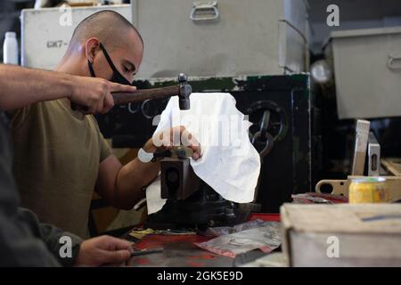 PAZIFIK (Aug 6, 2021) U.S. Marine Corps Sgt. Martin Vargas, ein Ch-53E Super Hengst Crew Chef mit Marine Medium Tiltrotor Squadron (VMM) 165 (verstärkt), 11th Marine Expeditionary Unit (MEU), montiert Teile für einen Ch-53E an Bord des Amphibientransportsdocks USS Portland (LPD 27), August 6. Marineinfanteristen und Matrosen der 11. MEU und der Essex Amphibious Ready Group (ARG) führen Routineoperationen in der 3. US-Flotte durch. Stockfoto