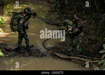 Tentara Nasional Indonesia (Indonesische Streitkräfte) überquert am 7. August 2021 einen Fluss während einer gemeinsamen Feldtrainingsübung im Baturaja Trainingsgebiet. Garuda Shield 21 ist eine zweiwöchige gemeinsame Übung zwischen der US-Armee und Tentara Nasional Indonesia (TNI-AD Indonesia Armed Forces). Der Zweck dieser gemeinsamen Übung ist es, die Dschungelkriegfähigkeit sowohl der US-Armee als auch der indonesischen Armee zu verbessern und zu bereichern. Stockfoto