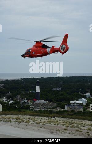 Eine Hubschrauber-Crew der US-Küstenwache MH-65D Dolphin von der Air Station Savannah, Georgia, fährt über die Tybee Island Light Station und das Museum auf dem Weg nach Charleston, S.C., 7. August 2021. Die Air Station Savannah ist für mehr als 450,000 Quadratmeilen Wasser von der Grenze zwischen Nord- und Südkarolina nach Süden bis Melbourne, Florida, und rund 100 Seemeilen auf See verantwortlich. Stockfoto