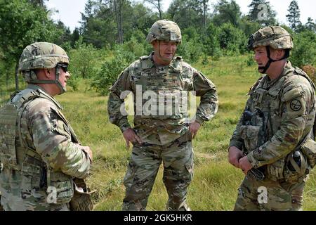 US Army Brig. General Bryan J. Grenon, stellvertretender Generalkommandant der Armee-Nationalgarde bei den Artillerierfeuern im Field Artillery Fires Center of Excellence, Fort Sill, Oklahoma, und der US-Armee Brig. General Lawrence E. Schloegl, stellvertretender Adjutant General, Michigan Army National Guard, wird vom US Army Cpt über den Status des Regiments auf dem Feld informiert. Johnny Kocher, Batteriekommandant des 201st Field Artillery Regiment, Fairmount, West Virginia, während des Northern Strike 21-2 im Camp Grayling Joint Maneuver Training Center, Grayling, Michigan, 8. August 2021. Grenon beobachtete Soldaten der Nationalgarde, wie sie comba dirigierten Stockfoto