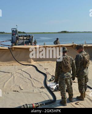 Marineinfanteristen vom 8. Ingenieur unterstützen Bataillon, Bulk Fuel Company 1st Platoon transferieren Treibstoff von zusammenklappbaren Stofftanks an Bord der Assault Craft Unit Two Landing Craft Utility 1662 in zusammenklappbare Stofftanks in Mile Hammock Bay, N.C. im Rahmen einer groß angelegten Übung (LSE 2021), 8. August 2021. LSE 2021 demonstriert die Fähigkeit der Marine, weltweit präzise, tödliche und überwältigende Gewalt über drei Seestreitkommandos, fünf nummerierte Flotten und 17 Zeitzonen hinweg einzusetzen. LSE 2021 vereint Live- und synthetische Trainingsfunktionen, um eine intensive, robuste Trainingsumgebung zu schaffen. Es verbindet sich hoch Stockfoto