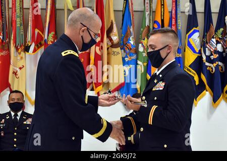 Der General-Adjutant Keith Waddell, General-Adjutant der Nationalgarde von Louisiana, überreicht dem Absolventen der Officer Candidate School den 2. LT. Andrew Broussard aus Youngsville, Louisiana, während der Abschlussfeier der Officer Candidate School im Camp Beauregard in Pineville, Louisiana, am 8. August 2021 den Adjutant General's Award. Broussard war einer von 15 Offizieren, die während der Zeremonie in Auftrag gegeben wurden und wird ein Offizier der 225. Ingenieur-Brigade sein. Stockfoto