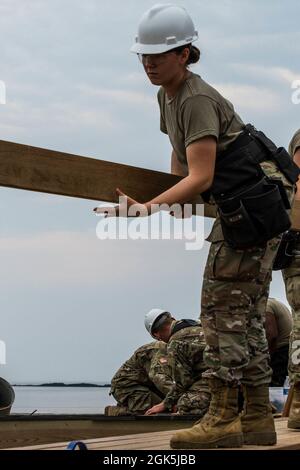 Pvt. First Class Jillian Ross, eine Fachkraft für Zimmerei und Mauerwerk bei der 185th Engineer Company, sammelt im Rahmen der jährlichen Schulung ihrer Einheit am 9. August 2021 in Kittery Materialien für den nördlichen Pier auf Wood Island. Die 185. Ingenieurgesellschaft arbeitete mit dem Wood Island Restoration Project zusammen, einem Komitee, das 2011 gegründet wurde, um Wood Island und die US-Rettungsstation wieder in ihr ursprüngliches und historisches Gesicht zu bringen. Stockfoto