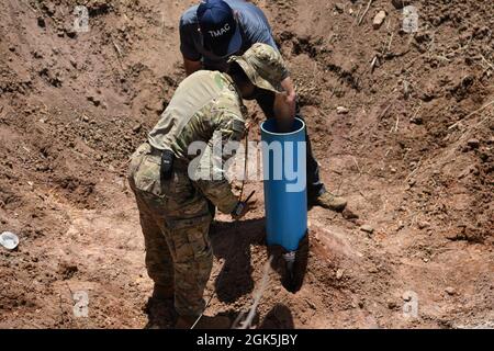 US Army Staff Sgt. Sierra Wright, ein Sprengstofftechniker mit der 74th Ordnance Company, dem 303rd Ordnance Bataillon und James Shelstad, einem technischen Berater für Sprengstoffentsorgung mit der Golden West Humanitarian Foundation, Bereiten Sie den Initiator vor, während der Übung Cobra Gold 21 auf dem Ta Mor ROI Trainingsgelände in der Provinz Surin, Thailand, am 8. August 2021, in einen binären Sprengstoff für die Detonation einer 155 Millimeter großen weißen Phosphor-Artillerie-Runde gesenkt zu werden. Die Royal Thai und die amerikanischen Streitkräfte arbeiteten während der Übung zusammen, um Landminenentsorgungsoperationen durchzuführen, die eine sichere Proce darstellen Stockfoto