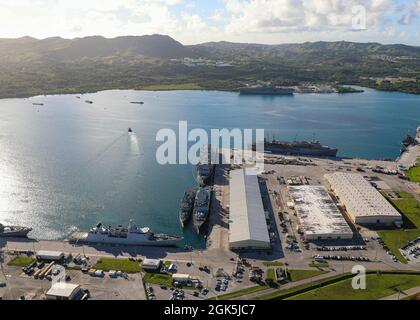 APRA HARBOUR, Guam (Aug 11, 2021) - eine Luftaufnahme des US-Marinestützpunktes Guam zeigt mehrere Schiffe, die in Apra Harbour festgemacht wurden, darunter Schiffe der britischen Carrier Strike Group 21, August 9. Die Stationierung ist die erste von einer Trägerstreikgruppe in Großbritannien seit fast 25 Jahren im Indo-Pazifik-Raum und stellt einen historischen Erfolg in der bilateralen Partnerschaft zwischen den USA und Großbritannien dar. Der geführte Raketenzerstörer der Arleigh Burke-Klasse, USS the Sullivans (DDG-68), wird mit der Streikgruppe eingesetzt, Ebenso wie F-35B Lightning II Joint Strike Fighters der Marine Fighter Attack Squadron 211, HMS Queen Elizabe Stockfoto