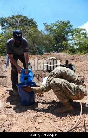 James Shelstad, ein technischer Berater für explosive Kampfmittelentsorgung mit der Golden West Humanitarian Foundation, Left, und dem US Army Staff Sgt. Sierra Wright, ein Sprengstofftechniker mit der 74th Ordnance Company, 303rd Ordnance Bataillon, übergibt während der Übung Cobra Gold 21 im Ta Mor ROI Trainingsgebiet in der Provinz Surin, Thailand, 8. August 2021 eine binäre Sprengflüssigkeit zur Detonation einer 155 Millimeter großen weißen Phosphor-Artillerie. Die Royal Thai und die amerikanischen Streitkräfte arbeiteten während der Übung zusammen, um Landminenentsorgungsoperationen durchzuführen, Render-Safe-Verfahrensschulungen durchzuführen und Stockfoto