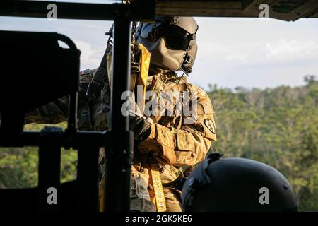 Ein Flug der US-Armee, ein Sanitäter mit Diamantkopf der Task Force, 25. Luftfahrtregiment, bereitet sich darauf vor, am 9. August 2021 im Baturaja Training Area, Indonesien, auf einen Jungle Penetrator, ein Werkzeug zur Gewinnung ambulanter Opfer aus stark bewaldeten Gebieten, heruntergehisst zu werden. Garuda Shield 21 ist eine zweiwöchige gemeinsame Übung zwischen der US-Armee und Tentara Nasional Indonesia (TNI-AD Indonesia Armed Forces). Der Zweck dieser gemeinsamen Übung ist es, die Dschungelkriegfähigkeit sowohl der US-Armee als auch der indonesischen Armee zu verbessern und zu bereichern. Stockfoto