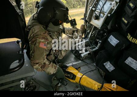 Ein US-Armeeflug-Sanitäter mit Diamantkopf der Task Force, 25. Luftfahrtregiment, bereitet am 9. August 2021 im Baturaja Training Area, Indonesien, einen Jungle Penetrator vor, ein Werkzeug, das verwendet wird, um ambulante Opfer aus stark bewaldeten Gebieten zu extrahieren. Garuda Shield 21 ist eine zweiwöchige gemeinsame Übung zwischen der US-Armee und Tentara Nasional Indonesia (TNI-AD Indonesia Armed Forces). Der Zweck dieser gemeinsamen Übung ist es, die Dschungelkriegfähigkeit sowohl der US-Armee als auch der indonesischen Armee zu verbessern und zu bereichern. Stockfoto