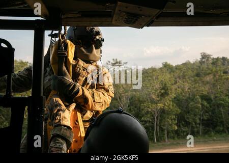 Ein Flug der US-Armee, ein Sanitäter mit Diamantkopf der Task Force, 25. Luftfahrtregiment, bereitet sich darauf vor, am 9. August 2021 im Baturaja Training Area, Indonesien, auf einen Jungle Penetrator, ein Werkzeug zur Gewinnung ambulanter Opfer aus stark bewaldeten Gebieten, heruntergehisst zu werden. Garuda Shield 21 ist eine zweiwöchige gemeinsame Übung zwischen der US-Armee und Tentara Nasional Indonesia (TNI-AD Indonesia Armed Forces). Der Zweck dieser gemeinsamen Übung ist es, die Dschungelkriegfähigkeit sowohl der US-Armee als auch der indonesischen Armee zu verbessern und zu bereichern. Stockfoto