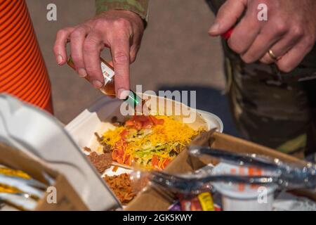 Die Flieger der 114. Force Support Squadron servieren Mittagessen vom Disaster Relief Mobile Kitchen Trailer, oder DRMKT, während der 2021 Readiness Übung im Joe Foss Field, South Dakota, am 5. August 2021. Das 114. Force Support Squadron nutzte das DRMKT als Teil des Multicapable Airman Trainings während der 2021 Readiness Übung. Stockfoto