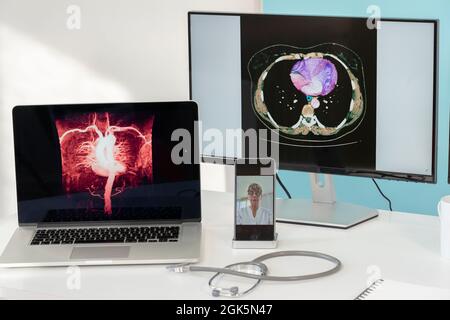 Telekonsultation zwischen zwei Ärzten mit medizinischen Bildern von Mägen auf einem der Bildschirme. Stockfoto