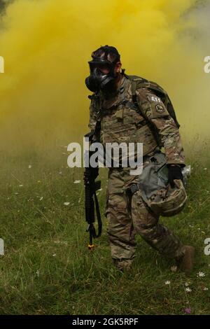 US Army Chief Warrant Officer 2 Miles Ray bewegt sich nach einem simulierten Gasangriff während des European Best Warrior Competition auf dem Hohenfels Training Area, Deutschland, am 10. August 2021, in ein klares Gebiet. Der European Best Warrior Competition ist ein sechstägiges Event, bei dem die Teilnehmer eine Vielzahl von Aufgaben und Missionen meistern müssen, die darauf ausgelegt sind, ihre Kampfkenntnisse, ihre körperliche Fitness, ihre Fähigkeiten auf dem Schlachtfeld in praktischen und situativen Tests sowie individuelle mündliche und schriftliche Prüfungen zu testen. Stockfoto