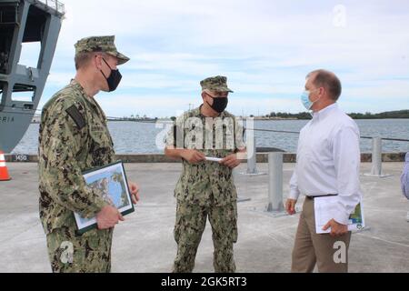 SANTA RITA, Guam (Aug 11, 2021) - der Delegierte des Kongresses, Robert Winkler, traf sich mit dem Kommandanten des US-Marinestützpunktes (NBG), Kapitän Michael Luckett und dem Beamten des NBG für öffentliche Arbeiten, Cmdr. Nichola Leinweber während eines Besuchs und einer Führung durch die Installation, August 10. Während seiner Zeit bei NBG besichtigte Winkler verschiedene Installationseinrichtungen, um laufende Bauprojekte an den Kais von X-Ray und Lima zu umfassen. Die Gespräche umfassten auch das kritische Infrastrukturprojekt, um die strategische Verlegung und Reparatur von U-Booten für die Defense Access Road Route 5, die zum NBG Ordnance Annex führt, zu treffen. Sie sprachen auch über q Stockfoto