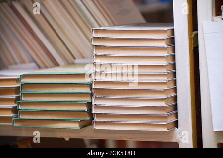 Bücherstapel auf einem Regal in der Bibliothek. Selektiver Fokus Stockfoto