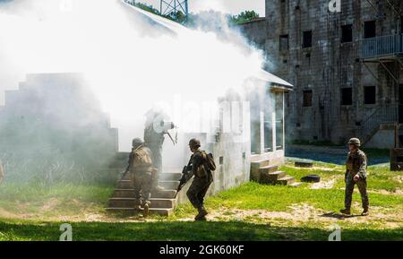 Marines mit Alpha Company, Marine Barracks Washington, führen militärische Operationen in städtischem Gelände durch Training auf der Marine Corps Base Quantico, VA., 11. Juli 2021. Die Marineinfanteristen lernten, praktizierten und implementierten mehrere verschiedene Verfahren: Übergriffen auf ein Gebäude, Räumung von Räumen und Treppenhäusern sowie verschiedene Techniken beim Navigieren in Fluren und engen Quartieren. Sie beendeten die Übung mit Simulationsmunition und nahmen an fiktiven Trupp-versus-Trupp-Engagements Teil, um ein lebendes urbanes Umfeld besser zu simulieren. Stockfoto