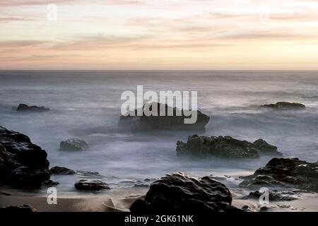 Lange Meereslandschaft in der Abenddämmerung. Nördliche portugiesische Felsküste. Stockfoto