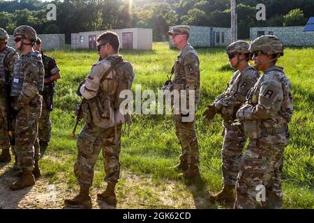 Beobachtertrainer/Trainer der 4th Cavalry Multi-Functional Training Brigade beobachten Soldaten der US Army Reserve mit der 196th Transportation Company, wie sie versuchen, eine Begegnung mit lokalen Staatsbürgern während einer wichtigen Führungseinbeziehung als Teil einer situativen Trainingsbahn bei der Combat Support Training Übung zu deeskalieren 78-21-04 am 11. August, 2021 in Fort McCoy, Wisconsin. OC/TS spielen eine entscheidende Rolle bei der Bereitstellung von Feedback an die Einheit, informell, durch alltägliche Interaktionen und formell durch mittlere und abschließende Nachbesprechungen. Stockfoto