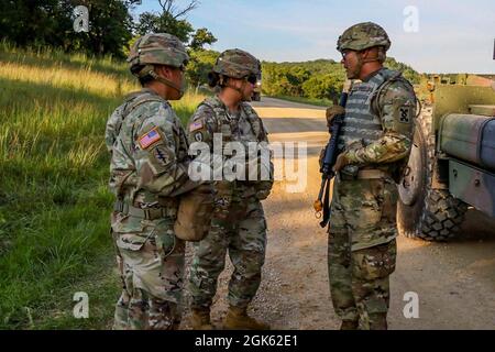 Capt. Crystal Morris (Mitte) und Sgt. Jessica Casillas der 1. Klasse (links), Beobachtercoach/Trainer mit 4th Cavalry Multi-Functional Training Brigade, Konvoi-Kommandant der Nachbesprechung, Sgt. Braulio Eduardo (rechts) mit der 196. Transportation Company nach einem wichtigen Engagement als Führungskraft im Rahmen der situativen Trainingsbahn bei der Combat Support Training Übung 78-21-04 am 11. August 2021 in Fort McCoy, Wisconsin. OC/TS sind Fachexperten für Lehrmeinungen und sind zertifiziert, Trainingsübungen zu beobachten, Einzelpersonen und Einheiten zu coachen und zu Schulen und nach den Übungen Input zu geben, um die Einleseübungen weiter zu verbessern Stockfoto