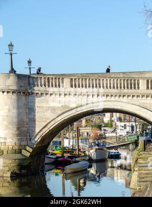 Festfahrende Boote auf der Themse, die durch einen Bogen von Richmond Bridge, Richmond-upon-Thames, Surrey, England, betrachtet werden. Stockfoto