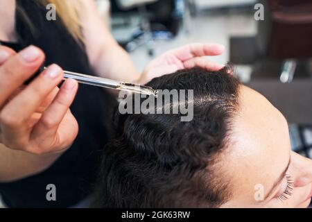 Nahaufnahme einer Frau, die Serum auf die Haare tropft Stockfoto