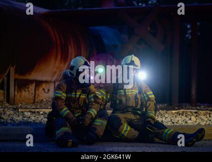 Feuerwehrmänner mit den lettischen nationalen Streitkräften und den estnischen Verteidigungskräften sitzen während einer Flugzeug-, Rettungs- und Feuerwehrausbildung im Alpena Combat Readiness Training Center, Michigan, 12. August 2021, am Boden. Sie waren Teil von Northern Strike 21-2, einer von der US-Nationalgarde gesponserten Übung, die die Möglichkeit bietet, Interoperabilität mit anderen Einheiten und multinationalen Partnern aufzubauen, während sie in realistischen Multi-Domain-Umgebungen geschult werden. Stockfoto