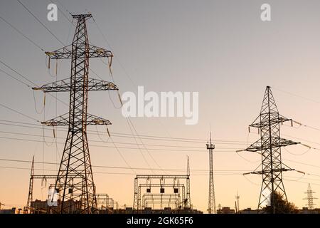 Stromverteilerstation. Hochspannungsturm für elektrische Übertragung. Verteilerstation mit Stromleitungen und Transformatoren. Stockfoto