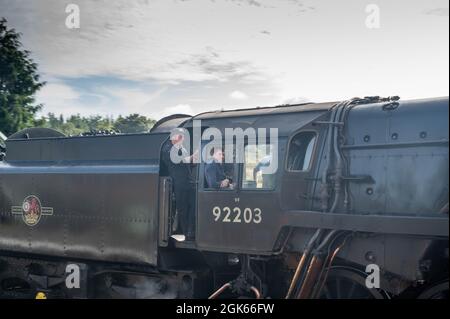 Die Dampflokomotive Black Prince kommt am Weyborne Bahnhof Norfolk an, die Fahrer lehnen sich aus dem Zug Stockfoto