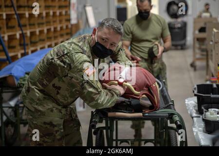 Cpt. Chad Warren, ein Offizier des 7301st Medical Training Support Bataillons, bereitet den Cut-Anzug vor, um am 14. August 2021 in Fort McCoy, Wisconsin, ins Feld zu gehen. Diese Trainingswerkzeuge werden bei der Übung „Combat Support Training“ verwendet, die von der 78. Trainingsdivision durchgeführt wird. Stockfoto