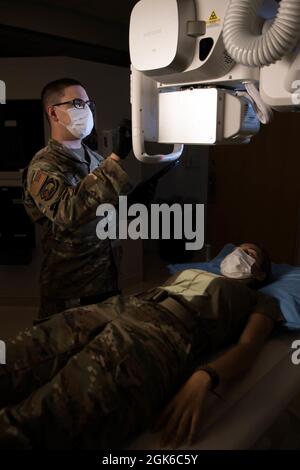 Technik. Sgt. Timothy Jenkins, Leiter der Abteilung für diagnostische Bildgebung des 436. Medizinischen Support-Squadron, bereitet sich auf eine Röntgenaufnahme der Brustwirbelsäule von Airman 1st Class Brianna Monteiro, 436. MDSS-Laborantin, auf der Dover Air Force Base, Delaware, 13. August 2021 vor. Radiology Airmen, die Dover AFB zugewiesen sind, führen eine dreijährige kontrollierte Tour durch, um die volle Unterstützung der Mission des Armed Forces Medical Examiner Systems zu ermöglichen. Stockfoto