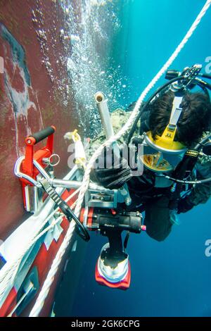 Brandon Barreto, der Marine Diver der 2. Klasse, der der Mobile Diving Salvage Unit (MDSU) 2 zugewiesen wurde, führt während eines großen Trainings (LSE 2021) Unterwasser-Kampfschadenreparaturen (BDR) auf dem Zerstörer USS Gonzalez der Arleigh Burke-Klasse (DDG 66) durch. LSE 2021 demonstriert die Fähigkeit der Marine, weltweit präzise, tödliche und überwältigende Gewalt über drei Seestreitkommandos, fünf nummerierte Flotten und 17 Zeitzonen hinweg einzusetzen. LSE 2021 vereint Live- und synthetische Trainingsfunktionen, um eine intensive, robuste Trainingsumgebung zu schaffen. Es wird High-Fidelity-Schulungen und den realen Betrieb mit bui verbinden Stockfoto