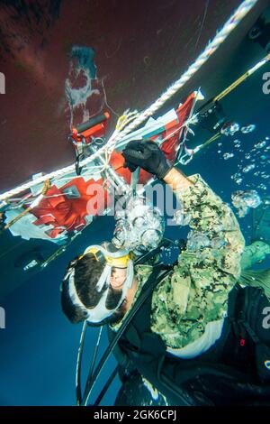Brandon Barreto, der Marine Diver der 2. Klasse, der der Mobile Diving Salvage Unit (MDSU) 2 zugewiesen wurde, führt während eines großen Trainings (LSE 2021) Unterwasser-Kampfschadenreparaturen (BDR) auf dem Zerstörer USS Gonzalez der Arleigh Burke-Klasse (DDG 66) durch. LSE 2021 demonstriert die Fähigkeit der Marine, weltweit präzise, tödliche und überwältigende Gewalt über drei Seestreitkommandos, fünf nummerierte Flotten und 17 Zeitzonen hinweg einzusetzen. LSE 2021 vereint Live- und synthetische Trainingsfunktionen, um eine intensive, robuste Trainingsumgebung zu schaffen. Es wird High-Fidelity-Schulungen und den realen Betrieb mit bui verbinden Stockfoto