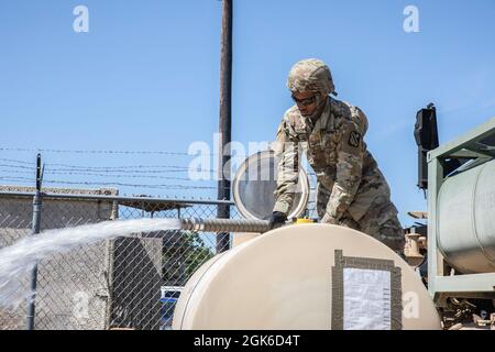 Pfc. Michael Landry, ein Wasseraufbereitungsspezialist bei der 303. Quartermaster Company aus Lake Charles, Louisiana, bereitet sich vor, während der Combat Support Training Exercise (CSTX) in Fort McCoy, Wisconsin, am 14. August 2021 einen Wasserbüffel zu füllen. CSTX bereitet Soldaten durch Szenarien vor, die den Einsatz von Konflikten gegen einen Gegner in der Nähe simulieren. Die richtige Flüssigkeitszufuhr trägt zur Soldier Readiness bei, indem sie die Widerstandsfähigkeit gegen hitzebedingte Verletzungen verbessert. Stockfoto