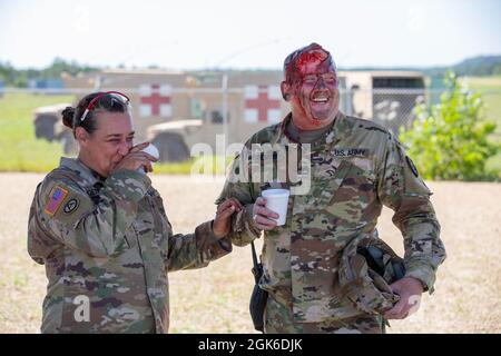 Sgt. First Class Kristina Boettcher, die nicht-kommissionierte Beauftragte für die Effekte und Enabler (E&E) von Global Medic, teilt sich einen Moment mit Sgt. Sam Hemphill der 1. Klasse, ein Reservesoldat der US-Armee von der 7239. Medizinischen Unterstützungseinheit, nach einer Massenausbildungsveranstaltung für das Combat Support Training Exercise (CSTX) in Fort McCoy, Wisconsin, am 14. August 2021. Die 78. Training Division war für diese Rotation von CSTX verantwortlich. Stockfoto