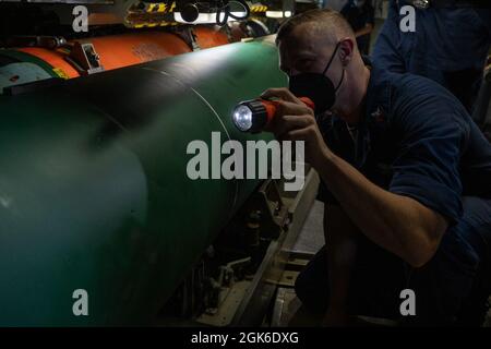 PAZIFIK (Aug 14, 2021) der Torpedoman der 1. Klasse Cameron Brown aus Jasper, Tennessee, inspiziert einen Aufsatz für eine UGM-84-Schiffsharpune-Rakete an Bord des Schnellangriffs-U-Bootes USS Chicago (SSN 721) der Los Angeles-Klasse während einer Großübung (LSE) 2021. LSE 2021 ist eine Live-, virtuelle und konstruktive, szenariogesteuerte, global integrierte Übung zur Bereitstellung von High-End-Schulungen auf See und an Land. Stockfoto