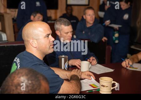 NUUK, Grönland -- (Aug 15, 2021) Lcdr. Kevin Robinson, der Executive Officer des USCGC Escanaba (WMEC 907), spricht während eines Navigationsbriefs mit Crew-Mitgliedern an Bord von Escanaba. Die Escanaba ist ein 270 Meter langer, berühmter Mittelausdauerschneider mit einer Besatzung von rund 100 Mitarbeitern, die viele Missionen des Dienstes durchführt und dabei auf Strafverfolgung und Sicherheit setzt. Stockfoto