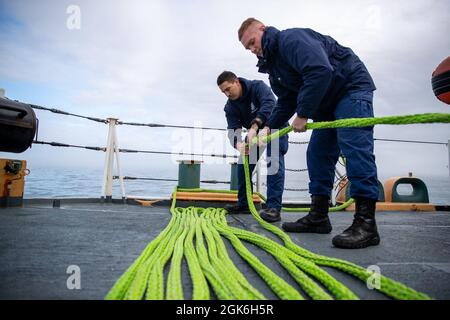 NUUK, Grönland -- (Aug 16, 2021) Seeleute, die dem 270-Fuß-Famous-Class-Medium-Endurance-Cutter USCGC Escanaba (WMEC 907) zugewiesen wurden, legten für die Operation Nanook Linien für die Hafenankunft in Nuuk, Grönland, fest. Die US-Küstenwache beteiligt sich erneut mit Partnern an der Operation Nanook, einer von den kanadischen Streitkräften durchgeführten Operation zur Souveränität und Manövrierkrieg. Stockfoto