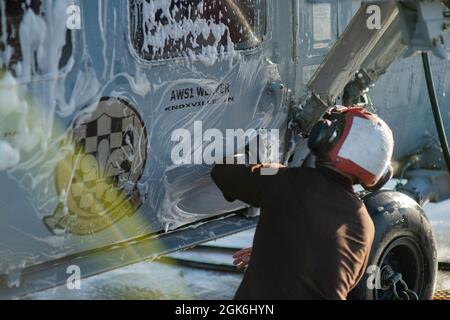 210816-N-TY704-2233 PACIFIC OCEAN (16. August 2021) Aviation Structural Mechanic Airman Apprentice Chaz Segress, ein gebürtiger aus Oklahoma City, reinigt einen MH-60S Sea Hawk, der den „Black Knights“ of Helicopter Sea Combat Squadron (HSC) 4 zugewiesen wurde, auf dem Flugdeck des Nimitz-Klasse-Flugzeugträgers USS Carl Vinson (CVN 70), August 16, 2021. Die Carl Vinson Carrier Strike Group (VINCSG) unter der Leitung der Carrier Strike Group (CSG) 1 wird derzeit zur Unterstützung globaler maritimer Sicherheitsoperationen eingesetzt. Stockfoto
