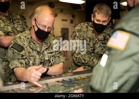 Vice Adm. Daryl Caudle, Commander, Submarine Forces (SUBFOR), links, erhält einen Brief von LT. Christopher Jones, USS Gerald R. Ford's (CVN 78) Aircraft Handling Officer, in Ford's Flight Deck Control während einer Tour des Schiffes, 16. August 2021. Caudle besuchte Ford mit ausgewählten SUBFOR- und US-amerikanischen Mitarbeitern der zweiten Flotte, um sich einen Einblick in die Materialbereitschaft des Schiffes nach den historischen Full Ship Shock Trials (FSST) von Ford zu verschaffen. Die US Navy führt Schockversuche an neuen Schiffsdesigns mit Live-Sprengstoffen durch, um zu bestätigen, dass unsere Kriegsschiffe weiterhin die anspruchsvollen Missionsanforderungen erfüllen können un Stockfoto